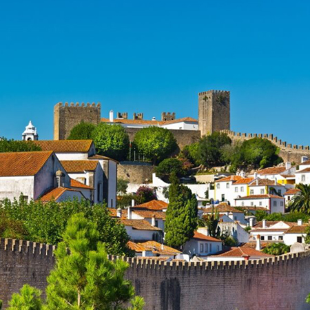 Vista sobre a vila de Óbidos, com as torres do castelo ao fundo.. Passagem obrigatória na rota das Antigas Judiarias em Portugal