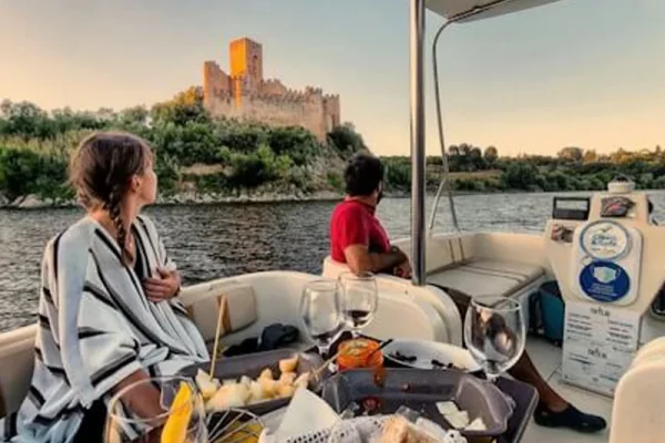 Almourol Castle in the background with two guests enjoying a private river cruise